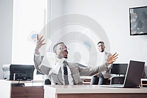 Two handsome cheerful african american businessman celebration successful with throwing paper in workplace