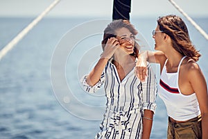 Two handsome female models enjoying the sun and the wind on a yacht on the sea. Summer, sea, vacation, friendship