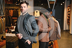 Two handsome respectable men in elegant classic suits in a premium men& x27;s clothing store