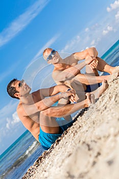 Two handsome young men chatting on a beach