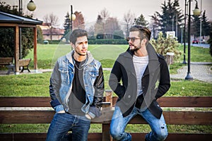 Two handsome young men, friends, in a park