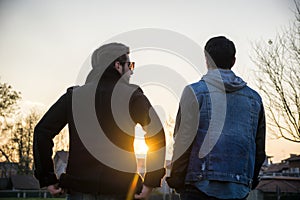 Two handsome young men, friends, in a park