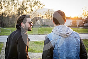 Two handsome young men, friends, in a park