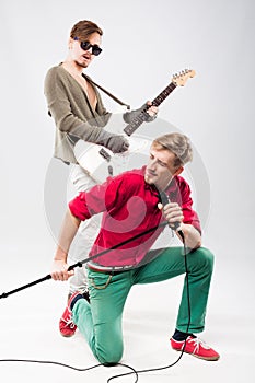 Two handsome young men with guitar and microphone