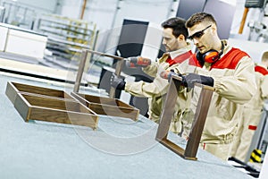 Two handsome young men working in furniture factory