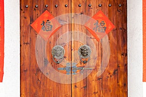 Two Handwriting Chinese blessing Fu on the  traditional chinese  wooden door with brass handle.