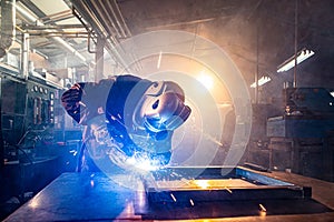 Two handymen welding and grinding metal at workshop