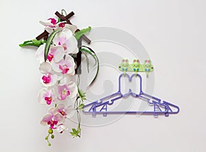 Two hanger on white wall near fake orchid