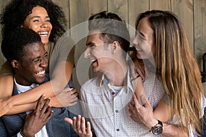 Two happy african and caucasian couples embracing having fun tog