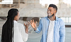 Two happy african friends meeting and greeting each other on street photo