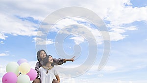 Two happy Asain girl holding balloon with blue sky background