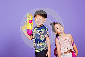 Two Happy Asian little boy and girl holding plastic water gun