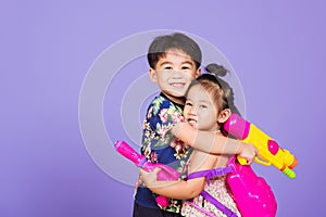 Two Happy Asian little boy and girl holding plastic water gun