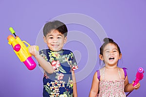 Two Happy Asian little boy and girl holding plastic water gun