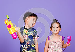 Two Happy Asian little boy and girl holding plastic water gun