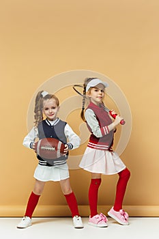 Two happy and beautyful children show different sport. Studio fashion concept. Emotions concept.