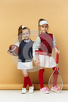 Two happy and beautyful children show different sport. Studio fashion concept. Emotions concept.