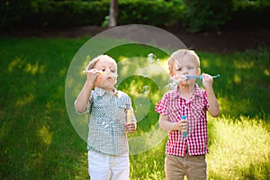 two happy boy play in bubbles outdoors