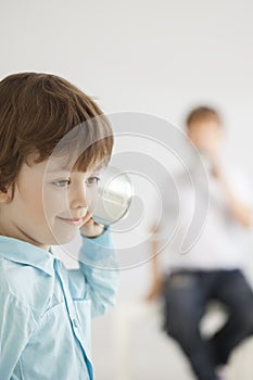 Two happy boy play in tin can phone
