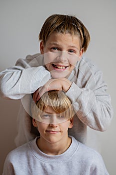 Two happy boys,brothers who are smiling together. twins und best friends. black and white , stay hags each other