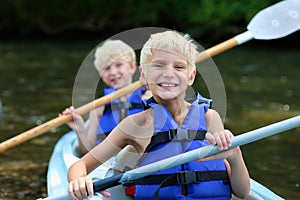 Two happy boys kayaking on the river