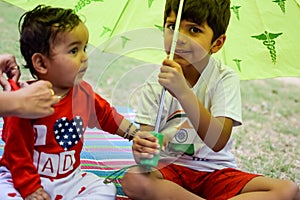 Two happy boys in society park, happy Asian brothers who are smiling happily together. Brothers play outdoors in summer, best