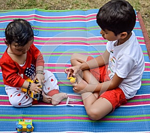 Two happy boys in society park, happy Asian brothers who are smiling happily together. Brothers play outdoors in summer, best