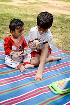Two happy boys in society park, happy Asian brothers who are smiling happily together. Brothers play outdoors in summer, best