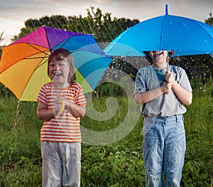 two happy brother with umbrella summer outdoors