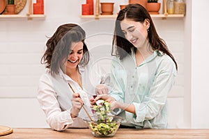 Due bruna le ragazze cucinando fresco insalata comune 