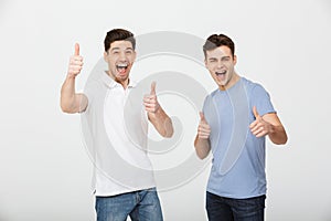 Two happy buddies 30s wearing casual t-shirt and jeans smiling a photo