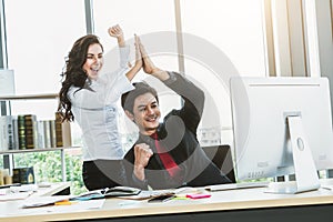 Two happy business people celebrate at office