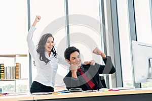 Two happy business people celebrate at office