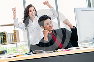 Two happy business people celebrate at office