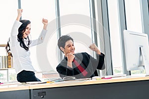 Two happy business people celebrate at office