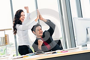 Two happy business people celebrate at office