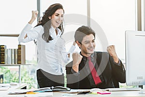 Two happy business people celebrate at office