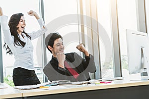 Two happy business people celebrate at office