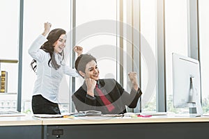 Two happy business people celebrate at office