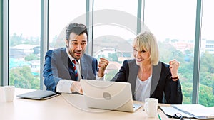 Two happy business people celebrate at office