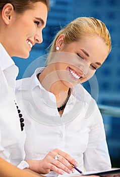 Two happy businesswomen with papers