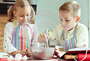 Two happy children baking christmas cookies at kitchen