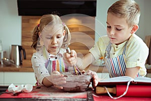 Two happy children baking christmas cookies at kitchen