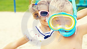 Two happy children, boy and a little toddler girl, brother and sister, playing on a beautiful tropical beach after