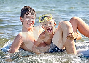 Two happy children laugh and bathe in the sea