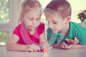 Two happy children playing with dices