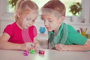 Two happy children playing with dices