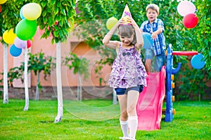 Two happy children sliding at playground