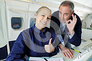 two happy co-workers showing ok sign