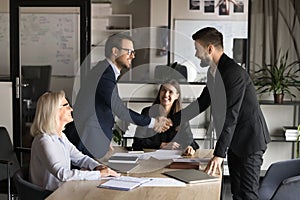 Two happy confident business partners men shaking hands